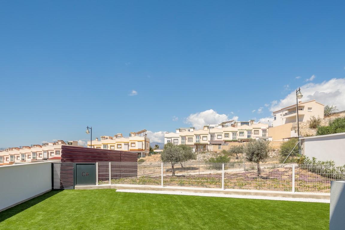 Aerial view of semi-detached homes, townhouses, and villas in Finestrat, Spain, surrounded by lush golf courses.