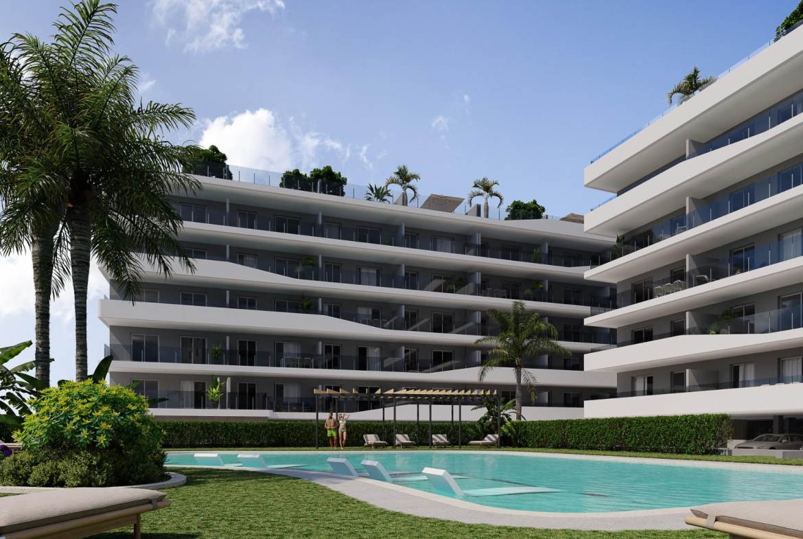 Aerial view of a modern residential complex with a swimming pool near the beach and golf courses in Costa Blanca, Spain.