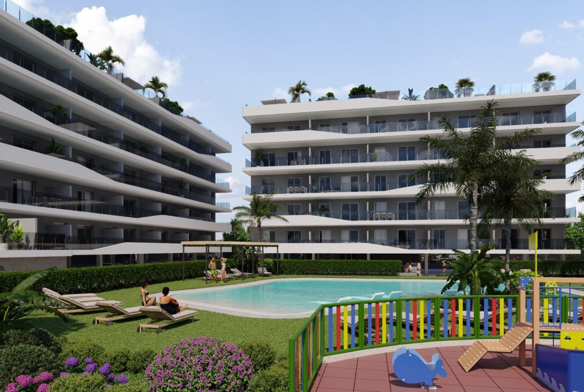 Aerial view of a modern residential complex with a swimming pool near the beach and golf courses in Costa Blanca, Spain.