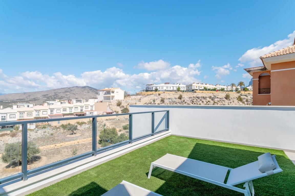 Aerial view of semi-detached homes, townhouses, and villas in Finestrat, Spain, surrounded by lush golf courses.